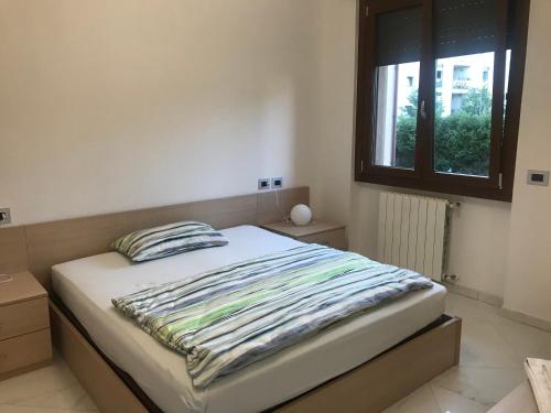 1 cama en un dormitorio con ventana en Erika modern apartment in Brianza, en Vimercate