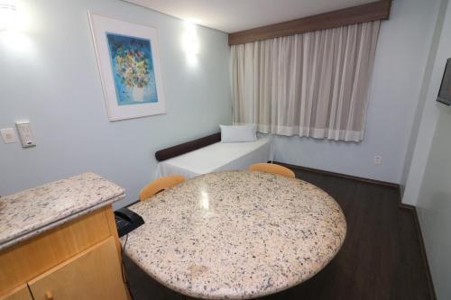 a room with a table with chairs and a counter at Hotel Nacional Inn São José dos Campos in São José dos Campos