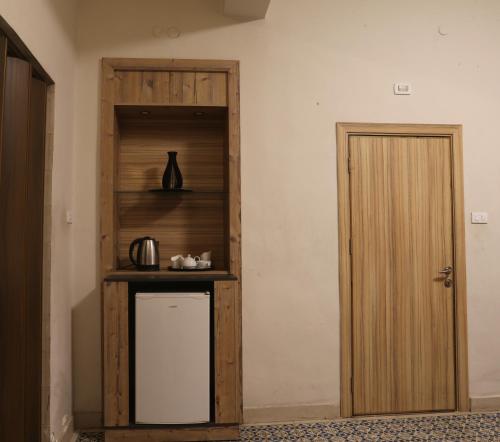 a room with a wooden shelf next to a door at Riviera Hotel in Amman