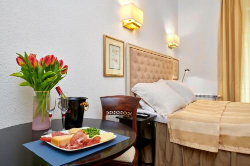una habitación de hotel con una mesa con un plato de comida en Little Roos, en Pula