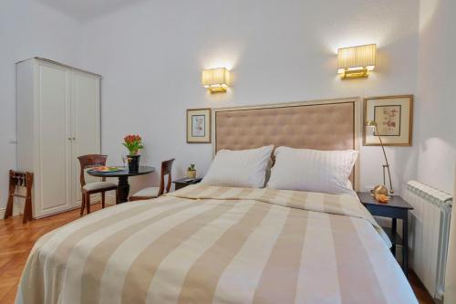 a bedroom with a large bed and a table at Little Roos in Pula