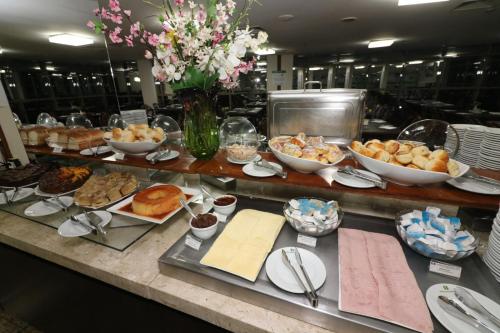 a buffet with many different types of food on a table at Hotel Nacional Inn São José dos Campos in São José dos Campos