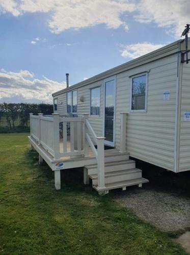 a large white mobile home with a large deck at 64 Southfield - Skipsea Sands in Ulrome