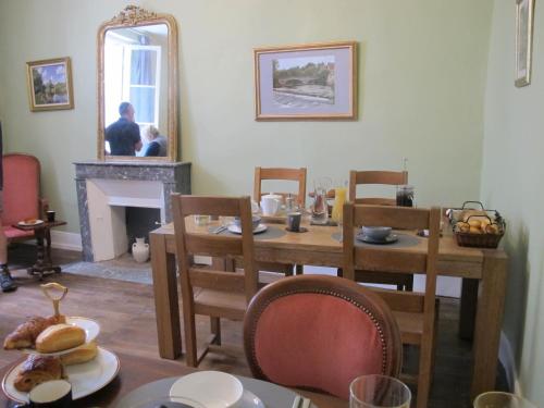 une salle à manger avec une table et une cheminée dans l'établissement ChezLola, à Civray