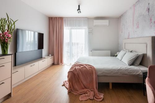 a bedroom with a bed and a flat screen tv at apartamenty-wroc Kurkowa in Wrocław