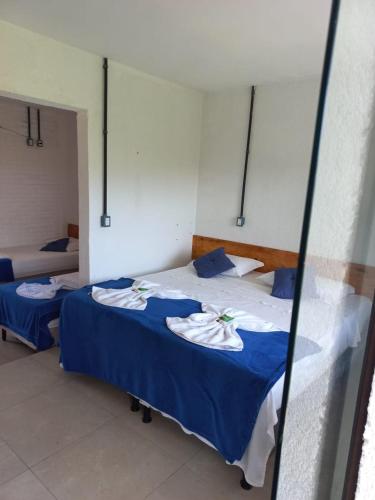 a bedroom with two beds with blue sheets at Pousada Brisa e Mar in Praia do Frances
