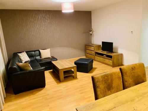 a living room with a couch and a table at RIVIERA LIPNO 502 Apartmán 4kk u vody in Lipno nad Vltavou