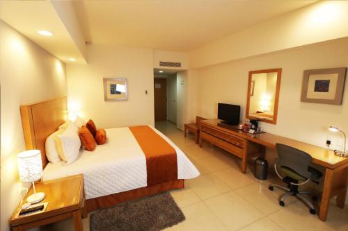 a hotel room with a bed and a desk and a computer at HB Córdoba in Córdoba