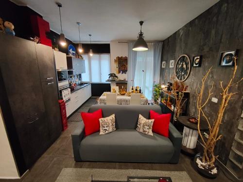 salon z szarą kanapą i czerwonymi poduszkami w obiekcie suite del borgo w Turynie