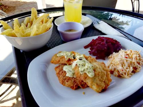 a plate of food with chicken and french fries on a table at Mashusha Bed & Breakfast in Gaborone