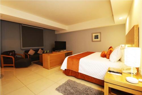 a hotel room with a bed and a flat screen tv at HB Córdoba in Córdoba