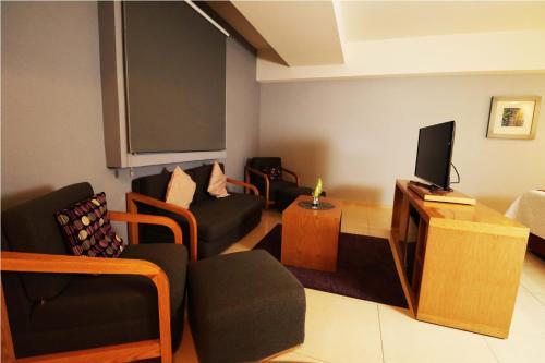 a living room with a couch and a tv at HB Córdoba in Córdoba