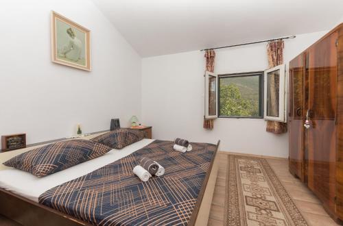 a bedroom with a bed with two pillows on it at Holiday home Frane in Slivno