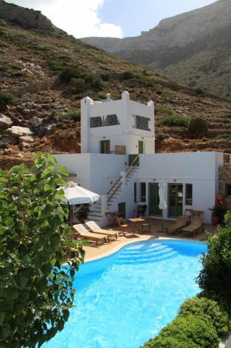 a villa with a swimming pool in front of a house at Margado in Kamarai