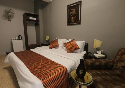 a bedroom with a large bed and a couch at Riviera Hotel in Amman