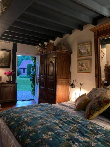 a bedroom with a large bed and a large window at La Ferme du Val de Lys in Nolléval