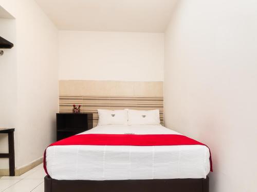 a bedroom with a large bed with a red blanket at Hotel Río in Puebla