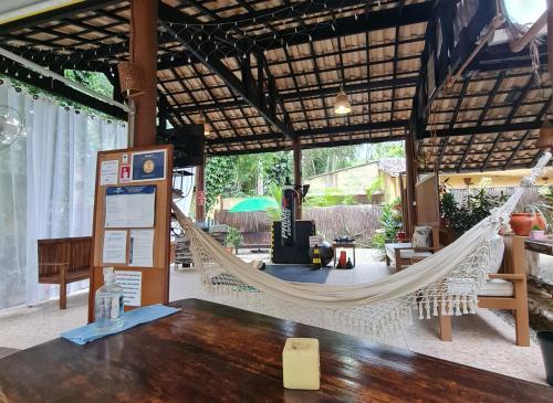 a hammock in a pavilion with a table at Nalu Guest House in Ubatuba