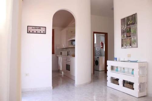 a kitchen with an archway in the middle of a room at Sol y Mar in Tarajalejo