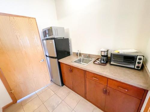 a small kitchen with a refrigerator and a microwave at Lake Bluff Inn and Suites in South Haven