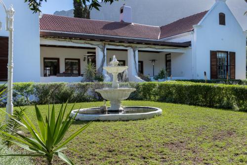 a fountain in the yard of a house at Anoud Manor in Hout Bay