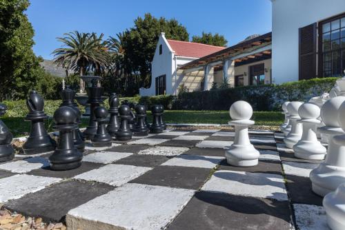 a chess set on a stone chessboard in front of a building at Anoud Manor in Hout Bay