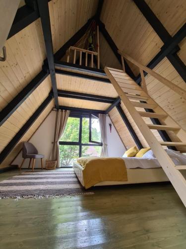 a bedroom with a bunk bed in a attic at Porumbacu Retreat-Cabana Forest A-frame și Chalet Max cu jacuzzi și piscină sezonieră, pe malul râului ,în apropiere de Transfăgărășan, Sibiu in Porumbacu de Sus