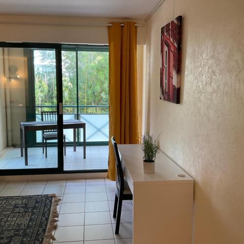 d'un salon avec une table et un balcon. dans l'établissement Studio Biarritz Aguilera 2 à 4 pers, à Biarritz