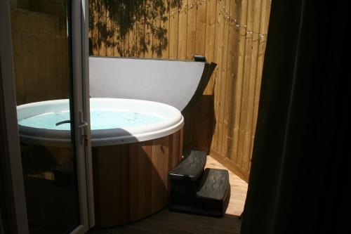 Snow Whites House - Farm Park Stay with Hot Tub في سوانسي: حمام مع حوض وحوض استحمام