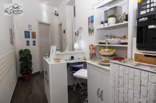 a kitchen with white cabinets and a counter top at B&B del Centro in Capo dʼOrlando