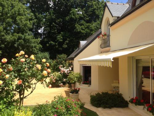 a house with a garden with roses in a yard at Chambres La Guignardais in Lamballe