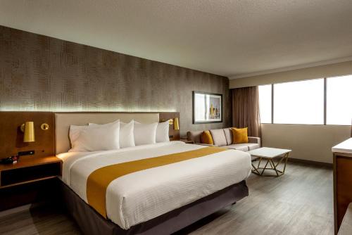 um quarto de hotel com uma cama grande e uma cadeira em Atlantica Hotel Halifax em Halifax