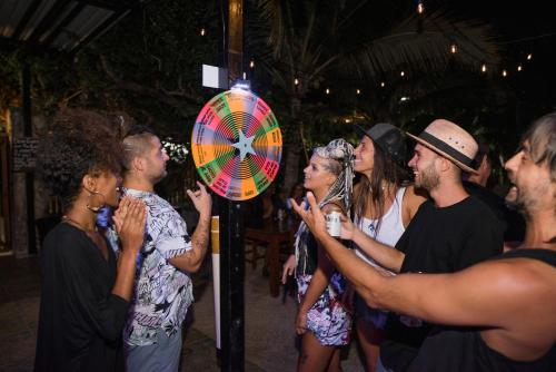 a group of people standing around a pinwheel at Che Holbox Hostel & Bar Adults Only in Holbox Island