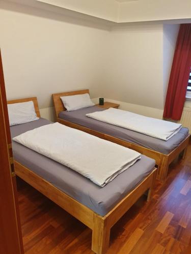 two twin beds in a room with wooden floors at Ferienwohnung Calabria Nr 3 in Mülheim an der Ruhr
