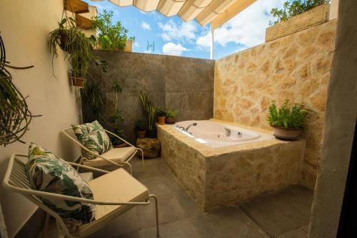 a bathroom with a tub and two chairs at la posada de consuelito in Chiloeches