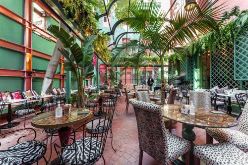 a restaurant with tables and chairs and plants at Snob Athens in Athens