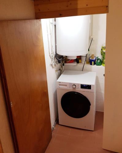 a kitchen with a microwave and a dryer in a room at Petit chalet rustique et bucolique in Bovernier