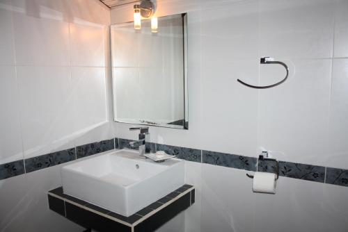 a bathroom with a white sink and a mirror at Saint Sofia Guest House Къща за Гости in Nesebar