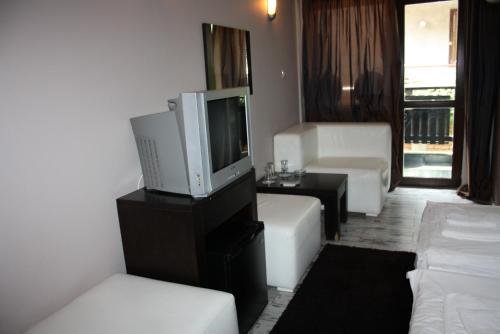 a living room with a tv and a couch at Saint Sofia Guest House Къща за Гости in Nesebar