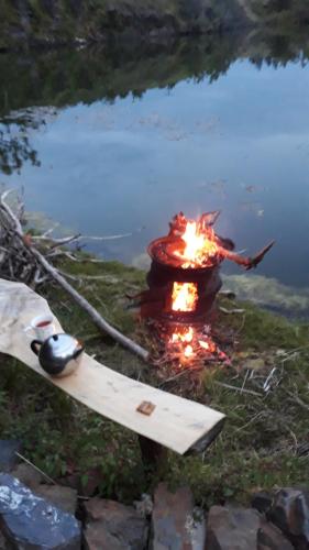 a fire pit with a board next to a pond at Garragh Mhor in Oban