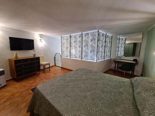 een slaapkamer met een bed, een ladekast en een televisie bij Pozzuoli Green house in Pozzuoli