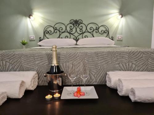 een bed met een tafel met een bord met eten en wijnglazen bij Pozzuoli Green house in Pozzuoli