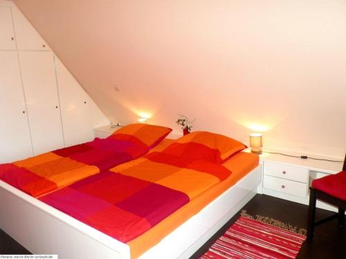 a bedroom with a bed with a colorful comforter at Pastoratshof - Whg8 in Wrixum
