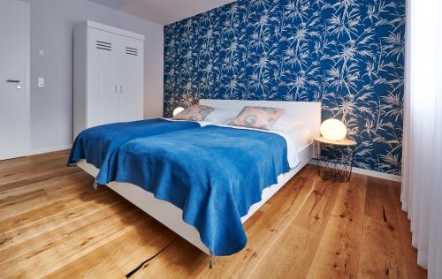 1 dormitorio con 1 cama con papel pintado azul y blanco en Bei Meyers - Ferienhaus Leipzig Neue Messe, en Leipzig