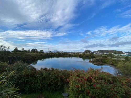 a river in a field with a cloudy sky at Garragh Mhor in Oban