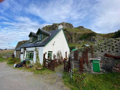 a small white house with a mountain in the background at Garragh Mhor in Oban
