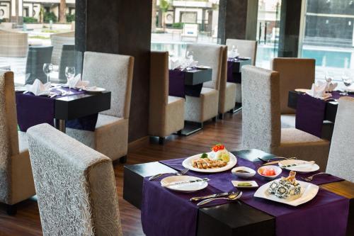 un comedor con una mesa con comida. en Golden Tulip Bhiwadi, en Dhāruhera