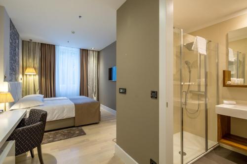une chambre d'hôtel avec un lit et une douche dans l'établissement Cornaro Hotel, à Split