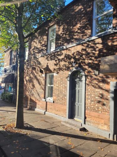 a brick building with a white door on a street at Carlisle City Centre, Cute Victorian House. in Carlisle