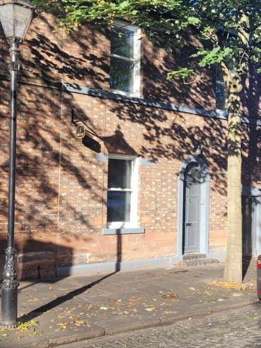 a brick building with a white door and a street light at Carlisle City Centre, Cute Victorian House. in Carlisle